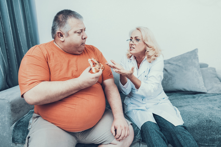 homem obeso recebendo bronca por comer pizza